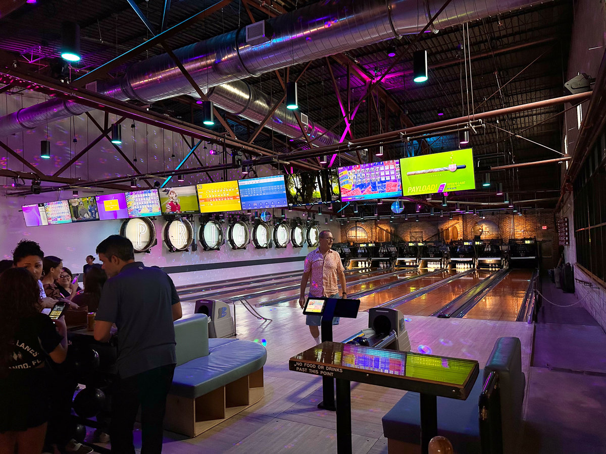 primrose bowling lanes with neon lights and people bowling